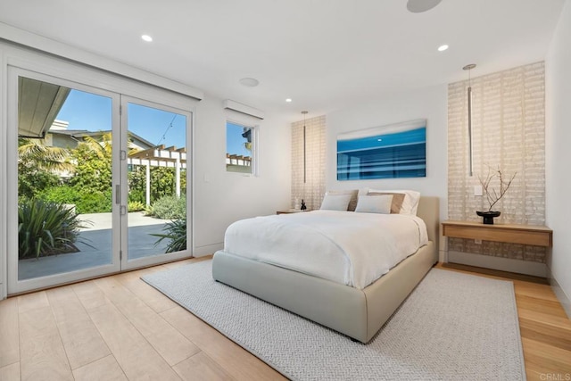 bedroom featuring access to outside, recessed lighting, a wall mounted air conditioner, and light wood-style floors