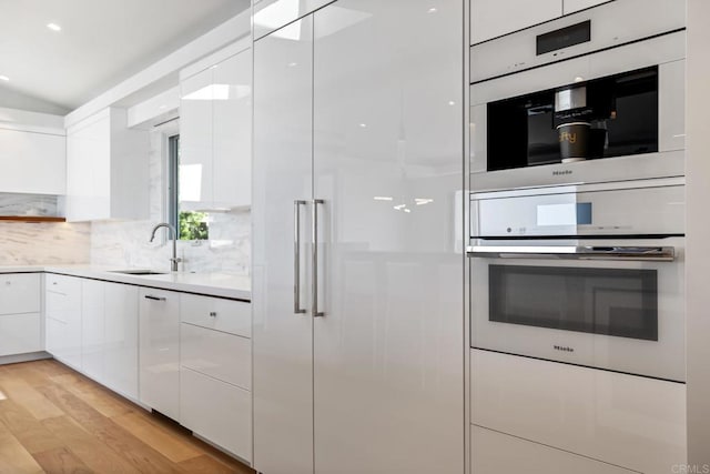 kitchen with light wood-style floors, modern cabinets, and white cabinets