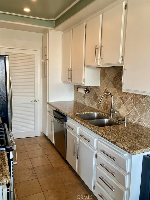 kitchen with a sink, appliances with stainless steel finishes, decorative backsplash, and white cabinets