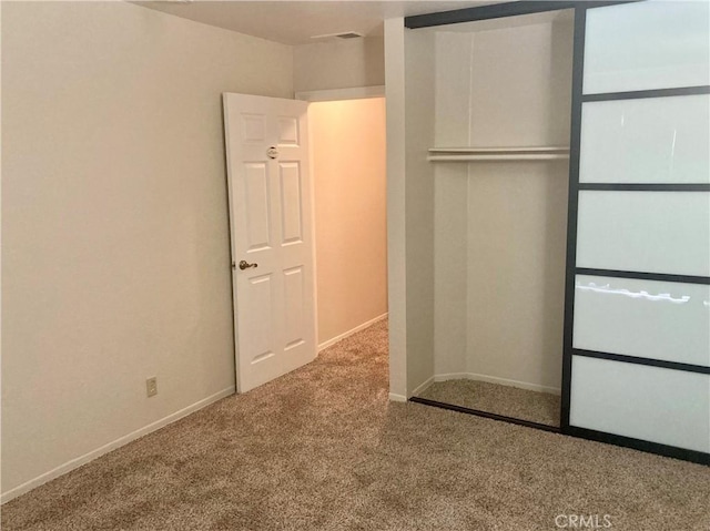 unfurnished bedroom featuring carpet floors, baseboards, and a closet