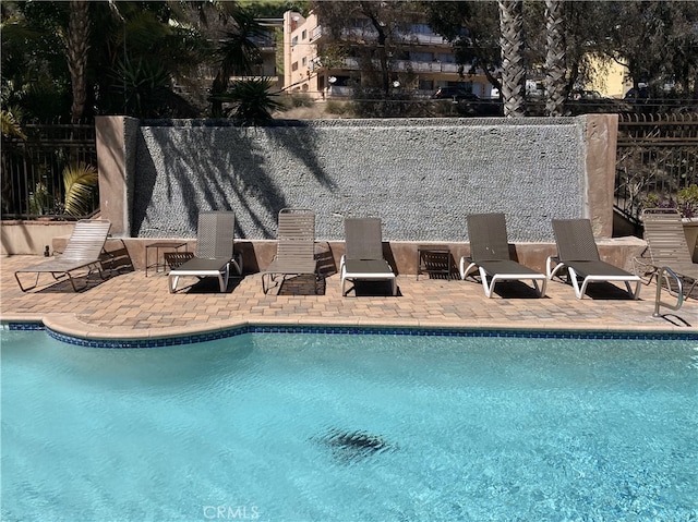 community pool featuring fence and a patio area