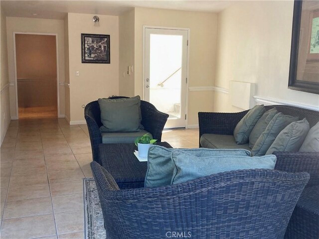 living area with light tile patterned floors and baseboards