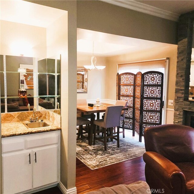 3800 Stocker St Unit 17, View Park, CA 90008 - dining area with dark wood-style flooring, a chandelier, wet bar, and crown molding