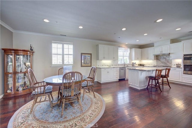 dining room with crown molding, baseboards, dark wood-style flooring, and recessed lighting