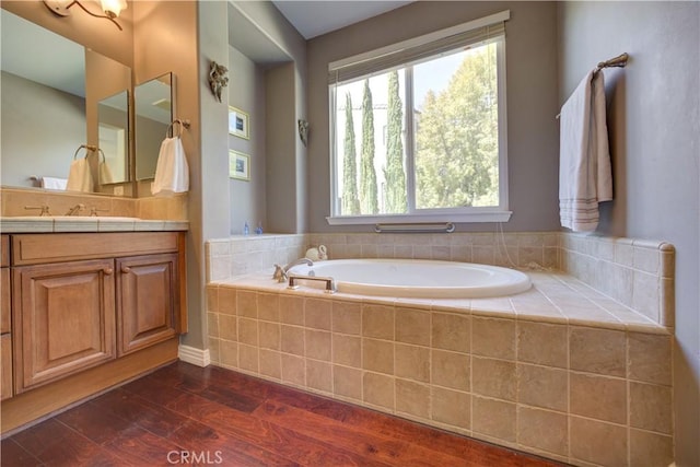 bathroom with vanity, a bath, and wood finished floors