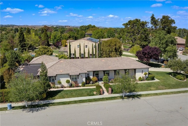 view of front of property featuring a tile roof and a front lawn