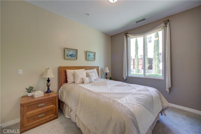 bedroom with baseboards, visible vents, and light carpet