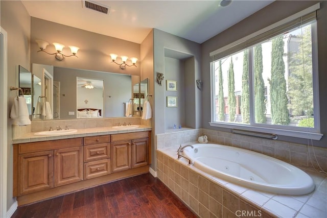 full bathroom featuring a sink, a jetted tub, double vanity, and visible vents