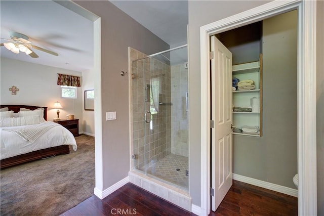 ensuite bathroom featuring a ceiling fan, ensuite bath, wood finished floors, and a shower stall