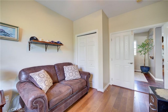 living area with baseboards and wood finished floors