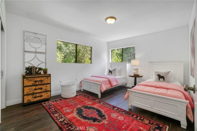bedroom with baseboards and dark wood-style flooring