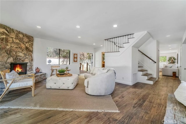 living room featuring recessed lighting, a fireplace, wood finished floors, and stairway