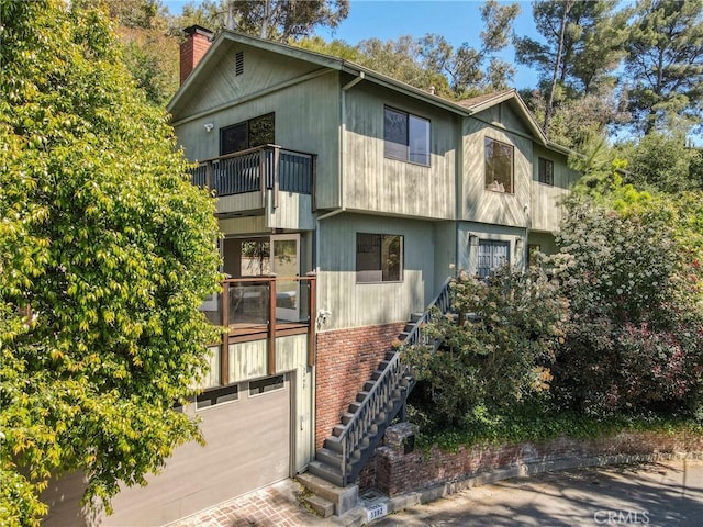 exterior space with stairs, decorative driveway, and an attached garage