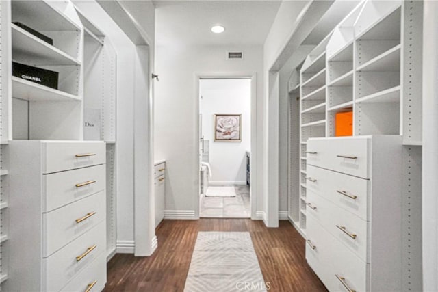 spacious closet featuring dark wood-style flooring and visible vents