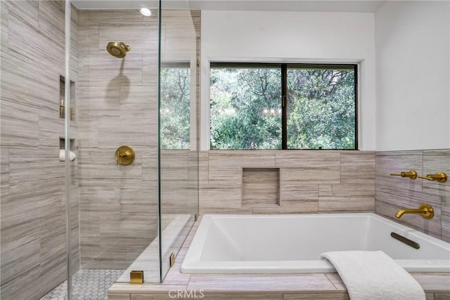 bathroom featuring a bathing tub and a shower stall