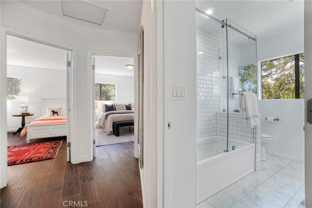 full bathroom featuring ensuite bathroom, bath / shower combo with glass door, and toilet