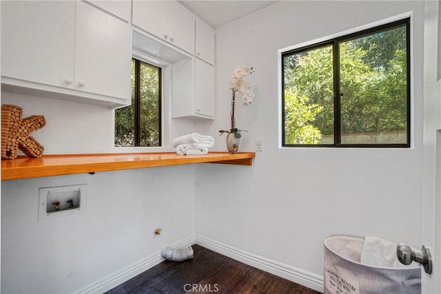 laundry area featuring dark wood-type flooring, cabinet space, baseboards, and washer hookup