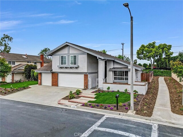 view of front of property featuring stucco siding, an attached garage, and driveway