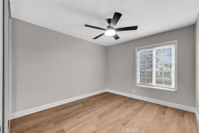 empty room featuring light wood-type flooring, baseboards, and ceiling fan