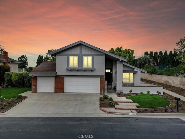 mid-century home featuring brick siding, an attached garage, stucco siding, and concrete driveway
