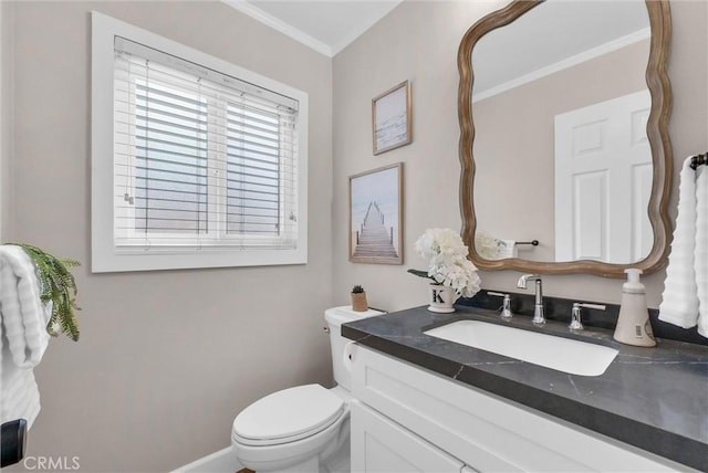 bathroom featuring toilet, baseboards, ornamental molding, and vanity