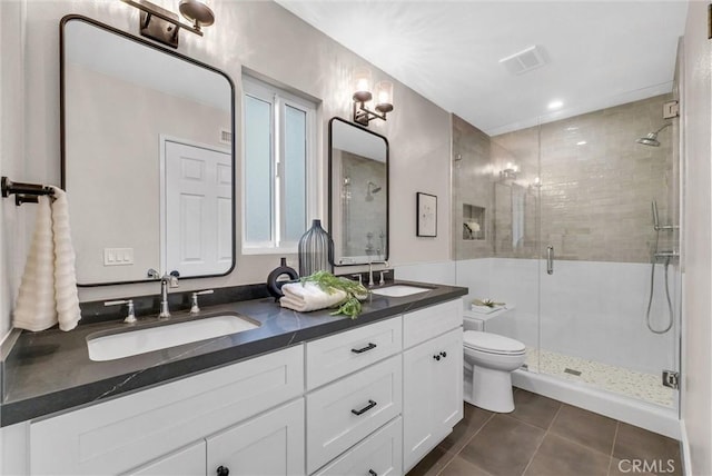 bathroom featuring a sink, tile patterned flooring, a shower stall, and double vanity
