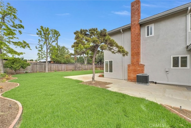 view of yard featuring a fenced backyard, central AC unit, and a patio area