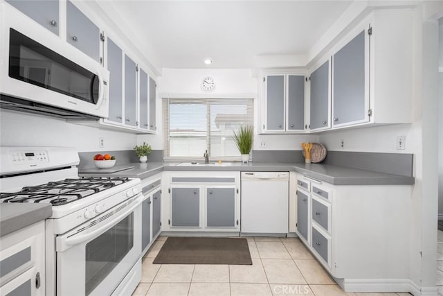 kitchen featuring a sink, light tile patterned floors, recessed lighting, and white appliances