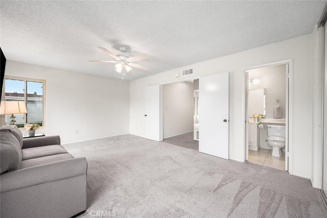 carpeted living room featuring a ceiling fan, a textured ceiling, and visible vents