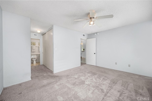 spare room with ceiling fan, carpet flooring, a textured ceiling, and visible vents