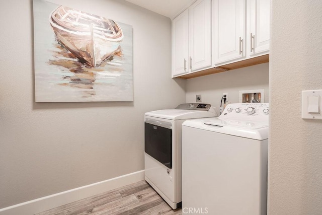 clothes washing area with cabinet space, independent washer and dryer, baseboards, and light wood finished floors