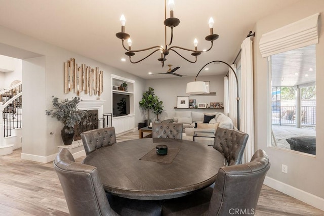 dining area featuring baseboards, built in shelves, a notable chandelier, and stairway