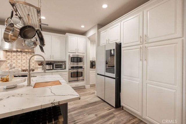 kitchen with white cabinets, recessed lighting, appliances with stainless steel finishes, and tasteful backsplash