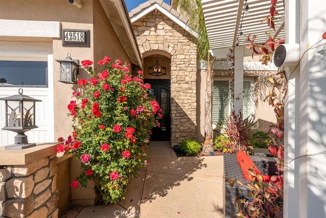 doorway to property with stone siding and stucco siding