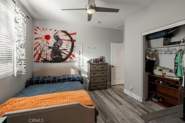 bedroom with baseboards, a ceiling fan, a closet, and wood finished floors
