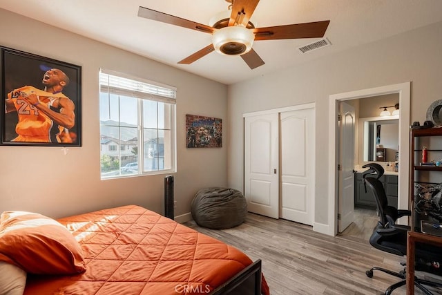 bedroom featuring a closet, visible vents, wood finished floors, baseboards, and a ceiling fan