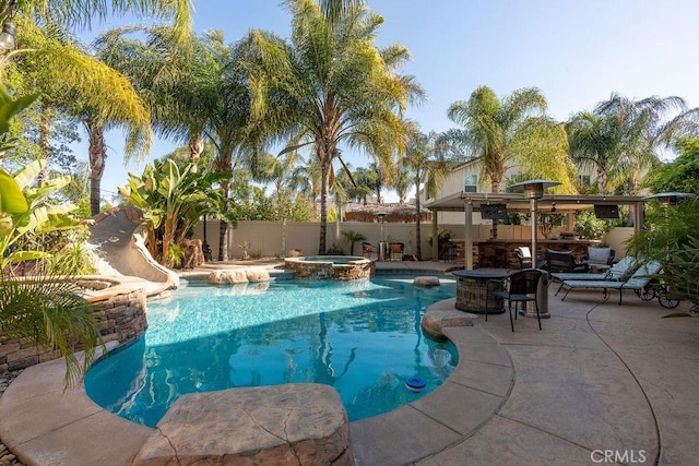 view of pool featuring a fenced backyard, a patio area, and a pool with connected hot tub