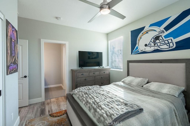 bedroom featuring a ceiling fan, baseboards, and wood finished floors