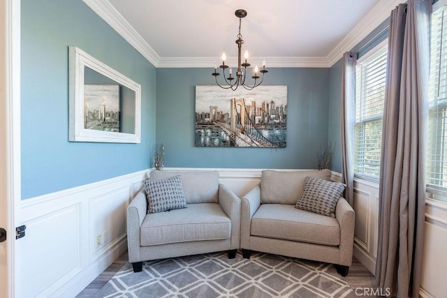 sitting room featuring crown molding, a decorative wall, a notable chandelier, and a healthy amount of sunlight