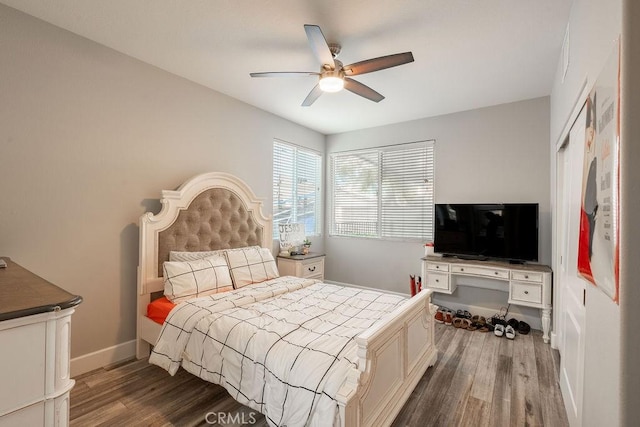 bedroom featuring baseboards, ceiling fan, and wood finished floors