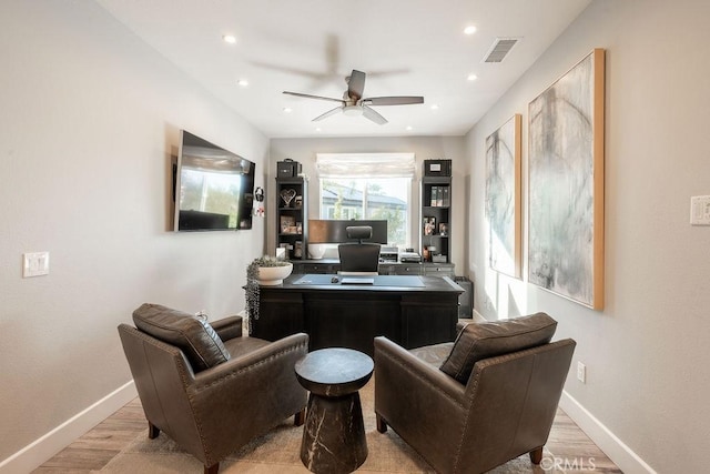 office space with baseboards, a ceiling fan, and light wood-type flooring