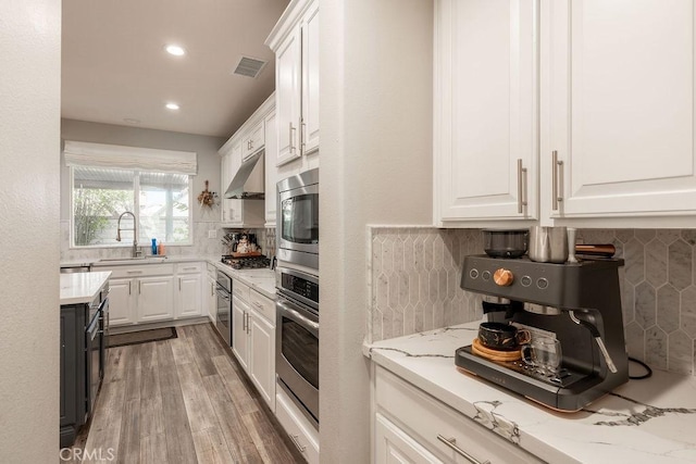 kitchen featuring visible vents, a sink, appliances with stainless steel finishes, and white cabinets