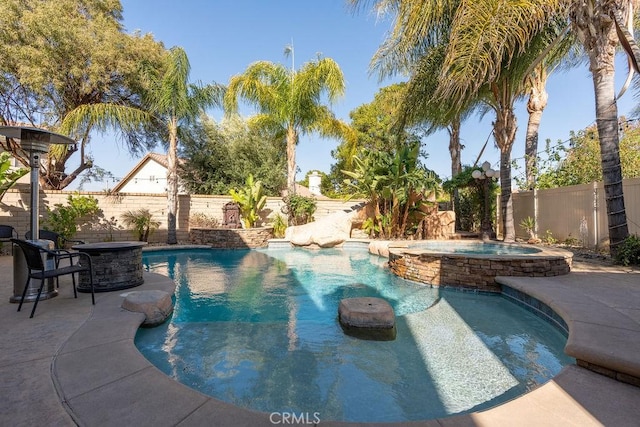 view of pool featuring a fenced backyard, a patio area, and a pool with connected hot tub
