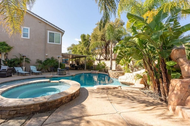view of swimming pool with a patio and a pool with connected hot tub