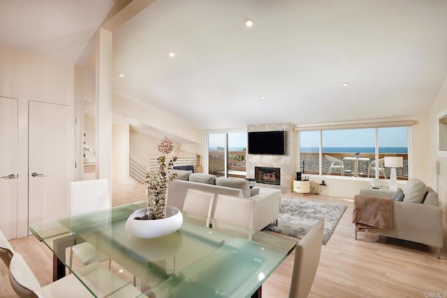 dining area featuring light wood-type flooring and a fireplace