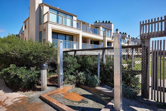 view of patio featuring fence and a balcony