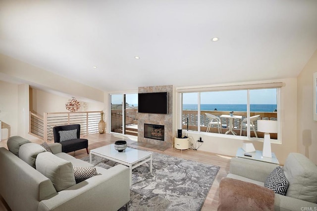 living room featuring recessed lighting, wood finished floors, vaulted ceiling, and a fireplace