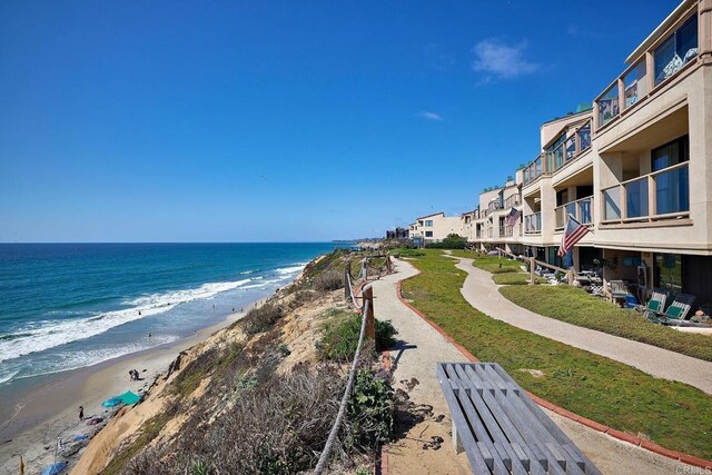 view of home's community featuring a beach view and a water view