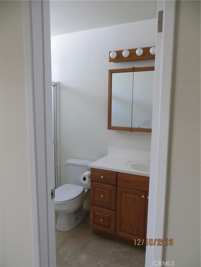 bathroom featuring vanity, tile patterned flooring, and toilet