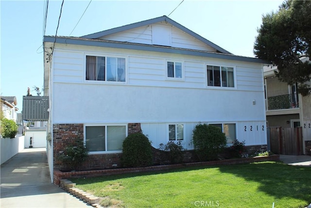 view of front facade featuring brick siding and a front yard